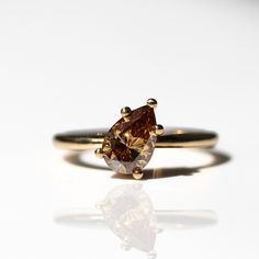 a yellow gold ring with a brown diamond