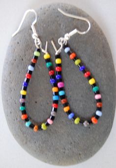 this is a handmade pair of rainbow beaded earrings. Colorful Czech Glass Round Beaded Earrings, Colorful Czech Glass Round Bead Earrings, Rainbow Beaded Dangle Hoop Earrings, Rainbow Polished Round Bead Jewelry, Rainbow Beaded Earrings With Ear Wire, Rainbow Earrings With Colorful Round Beads, Rainbow Spacer Beads For Jewelry Making, Colorful Beaded Round Earrings, Rainbow Earrings With Colorful Beads