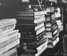 black and white photograph of stacks of books in a book store, with one stack on top of the other