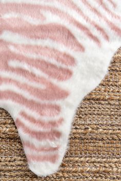 a close up of a pink and white rug on a woven piece of cloth with some sort of animal print