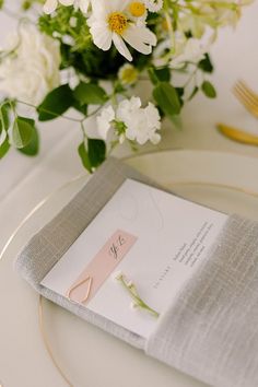 a place setting with flowers and napkins on the table for an elegant wedding reception