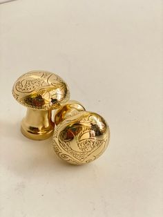 two golden knobs on a white surface