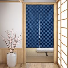 a vase with some flowers in it sitting next to a blue wall and wooden floor