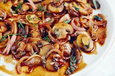 a white plate topped with sliced mushrooms and onions