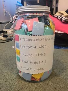 a jar filled with lots of different colored papers and some writing on it's side