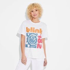 The Women's Blink 182 Short Sleeve Graphic T-Shirt in white is ideal for music lovers and fashion enthusiasts alike. This t-shirt features a graphic design of Blink 182’s iconic band logo for an added rock 'n’ roll flair to your ensemble. It is crafted from lightweight fabric for a comfortable and breathable feel. Whether you're hitting the streets or chilling with friends, the women's Blink 182 short sleeve graphic t-shirt in white is sure to make a statement. 90s Style White Graphic Print T-shirt, White Hip Hop T-shirt For Concert, Spring Band Logo Graphic Tee, Retro Concert T-shirt With Logo Print, 90s White Fan Merchandise T-shirt, Retro Logo Print T-shirt For Concert, White Band Logo T-shirt Crew Neck, Trendy Band Logo T-shirt For Summer, White Short Sleeve Top With Band Logo