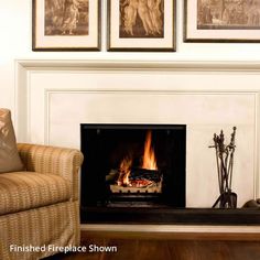 a fire place in a living room with pictures on the wall above and below it