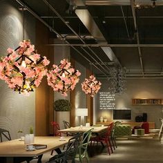 a room filled with lots of tables and chairs next to a tall chandelier