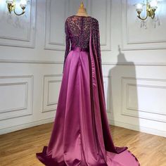 Gorgeous Grape Hue: A rich grape purple color that exudes sophistication and allure, making it an ideal choice for evening events and parties in 2024 . Elegant Silhouette: The dress boasts an elegant silhouette that drapes beautifully, enhancing your natural grace and charm. High Split: A high split in the skirt adds a touch of sensuality and allows for ease of movement, perfect for dancing and making a grand entrance. Luxurious Satin Fabric: The gown is crafted from luxurious satin fabric, addi Purple Evening Dress For Gala, Glamorous Purple Satin Evening Dress, Purple Long Sleeve Dress For Mother Of The Bride, Purple Long Sleeve Mother Of The Bride Dress, Purple Floor-length Dress For Banquet, Purple Long Sleeve Gown With Sweep Train, Purple Long Sleeve Banquet Gown, Long Sleeve Purple Gown For Banquet, Purple Fitted Evening Dress