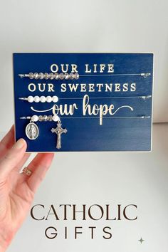 a hand holding up a card that says, our life our sweetness our hope catholic gifts