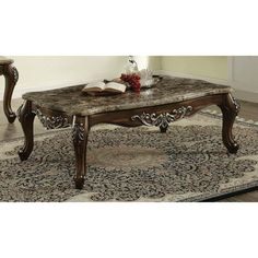 a marble top coffee table with two end tables next to it on an area rug