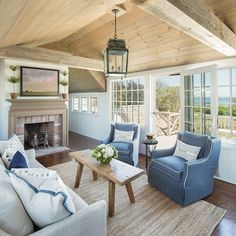 a living room filled with furniture and a fire place in front of a large window