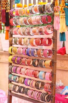 a rack filled with lots of different types of bracelets on top of a table