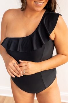 The standout feature of this swimsuit is the stylish ruffle detail, which adds a playful and feminine element to the overall design. The ruffle is strategically placed, enhancing the glamour of the one-shoulder silhouette. The combination of the sleek black color, the one-shoulder style, and the charming ruffle makes the Sophia Black One Shoulder One Piece a statement piece for those who appreciate both fashion and functionality in their swimwear.Fit: True To Size Material: 80% Nylon 20% Spandex Off-shoulder Ruffled Swimwear For Poolside, Chic Off-shoulder Ruffled Swimwear, Chic Black Off-shoulder Swimwear, One Shoulder Ruffled Swimwear For Summer, Fitted One-shoulder Swimwear With Ruffles, One-shoulder Ruffled Swimwear For Summer, Elegant Solid One-shoulder Swimwear, Elegant One-shoulder Solid Swimwear, One Shoulder Party Swimwear With Ruffles