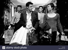 black and white photograph of people carrying shopping bags