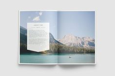 an open book with a photo of mountains in the background and a boat on the water