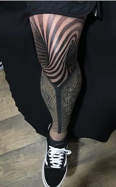 a man's leg with tattoos on it