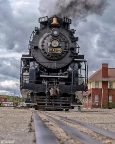 an old fashioned steam engine traveling down train tracks