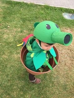 a little boy dressed up as a dinosaur in a pot with an animal mask on