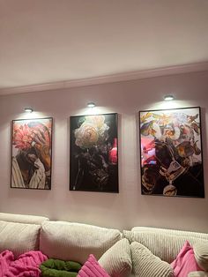 three paintings hang on the wall above a couch