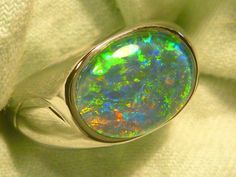 "As a rule the very best & highest quality stones are strictly reserved for our 14ct Gold range. Occasionally I set a few of the very best stones in the Sterling Silver range, this is one of those occasions. If you are prepared to pay a premium for the very best quality Opal , without the extra expense of a Solid Gold setting, this could suit. The ring is made from Sterling Silver & is fully \"J\" backed. The Gem Plus grade Triplet Opal is 14x10mm Oval & of the highest quality. The design featur Oval Gemstones With Polished Finish For Formal Occasions, Modern Oval Opal Ring For Formal Occasions, Oval Polished Gemstones For Formal Occasions, Classic Oval Opal Ring With Polished Finish, Luxury Green Oval Opal Ring, Classic Green Oval Opal Ring, Classic Oval Cabochon Opal Ring For Formal Occasions, Classic Formal Opal Ring Oval Cabochon, Classic Formal Opal Ring With Oval Shape