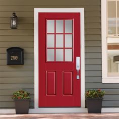 a red front door with two planters on the side and a mailbox next to it