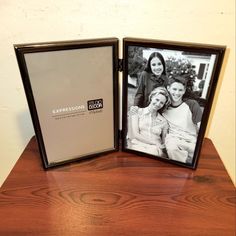 two framed photos sitting on top of a wooden table next to each other with the same photo in it