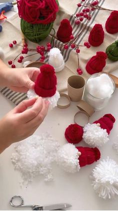 someone is making red and white pom poms