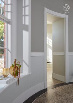 a vase with flowers sitting on the window sill in front of a door way