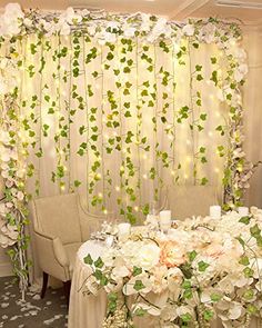 a table with white flowers and greenery on it