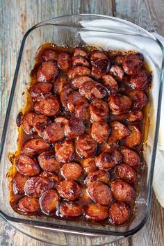 a glass casserole dish filled with cooked sausages