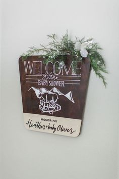 there is a sign that says welcome to the baby shower and has flowers on it