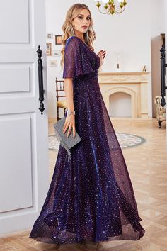 a woman in a long purple dress is standing by a door and looking at the camera