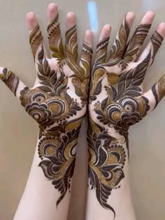 two hands with henna designs on them