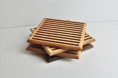 four wooden coasters stacked on top of each other in the shape of a square