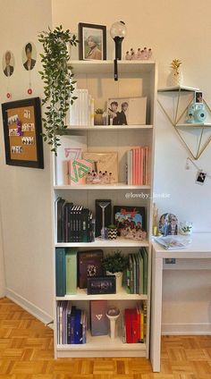 a bookshelf filled with lots of books on top of a hard wood floor