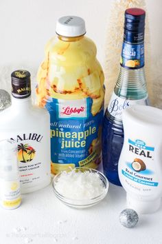 the ingredients to make pineapple juice are displayed on a white counter top, including coconuts and other items