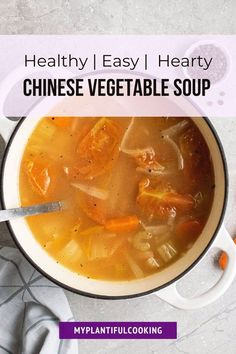 a bowl of soup with carrots and broth in it on top of a table