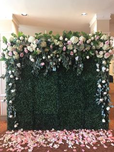 a green wall covered in flowers and greenery