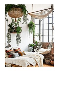 a bedroom with plants hanging from the ceiling and a bed in front of a window