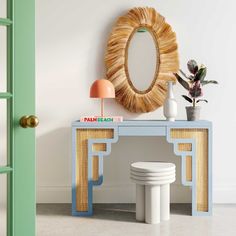 a white toilet sitting under a mirror next to a blue table with a potted plant on it