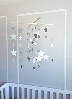 a baby crib with stars hanging from the ceiling