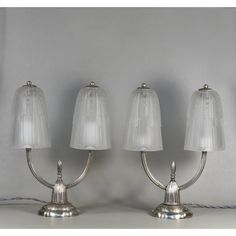 three lamps with white shades on them sitting next to each other