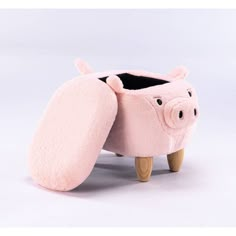 a pink pig planter sitting on top of a wooden stand