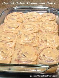 a pan filled with cinnamon rolls on top of a counter next to a glass container