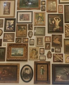 a wall covered in many different framed pictures