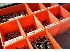 many orange bins filled with lots of screws and nuts