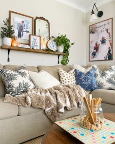 a living room filled with furniture and pictures on the wall above it's coffee table