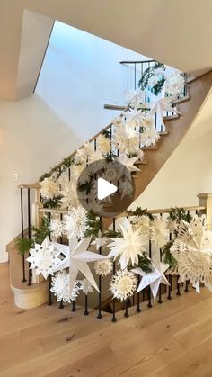 a staircase decorated with white snowflakes and greenery