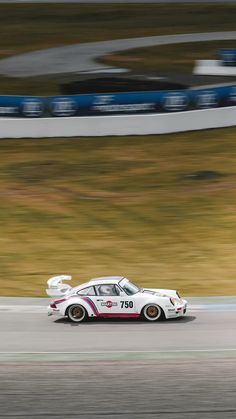 a white car driving down a race track